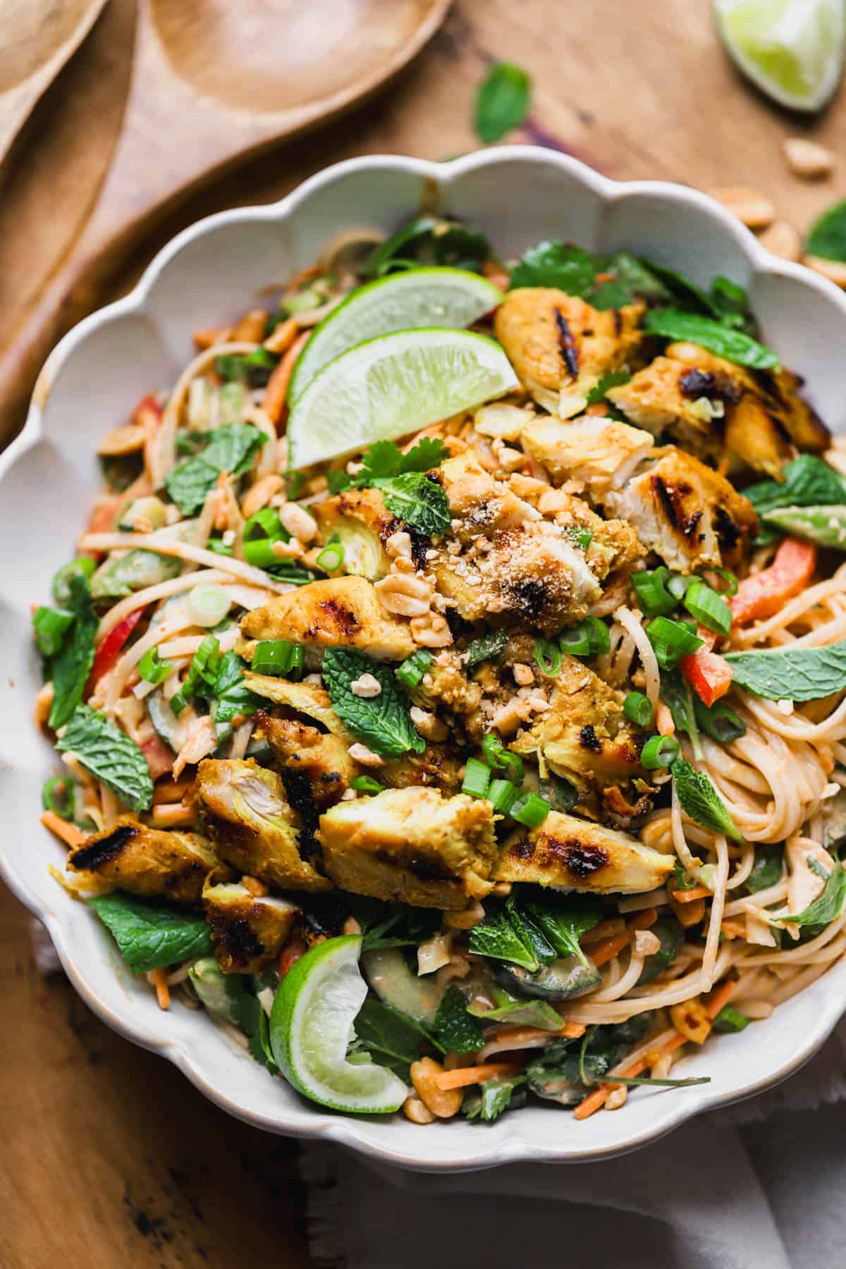 Thai chicken noodle salad with fresh veggies, rice noodles, peanut dressing, cilantro, mint and chopped peanuts.