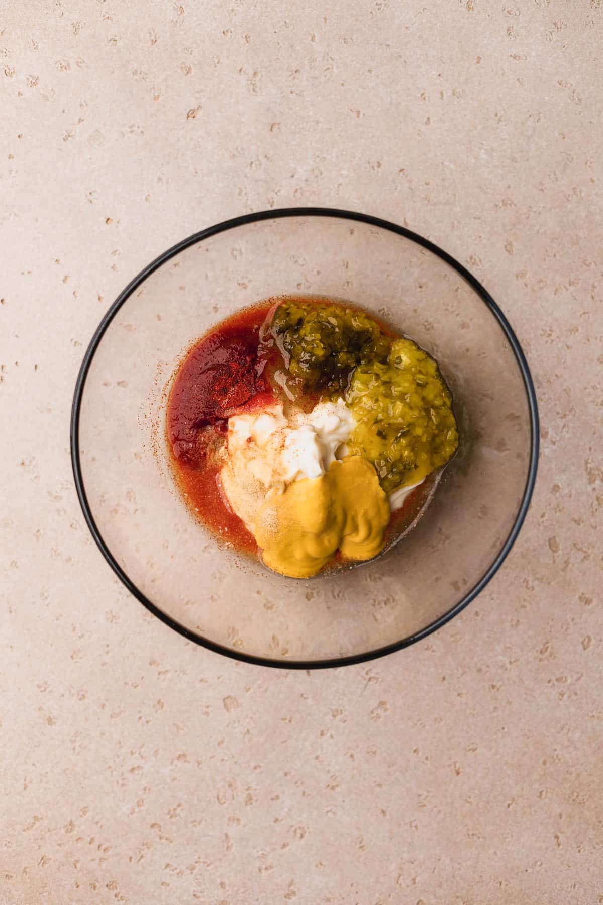 Mayo, sweet relish, dill relish, yellow mustard, paprika, garlic powder, onion powder, white vinegar, sugar, and ketchup.