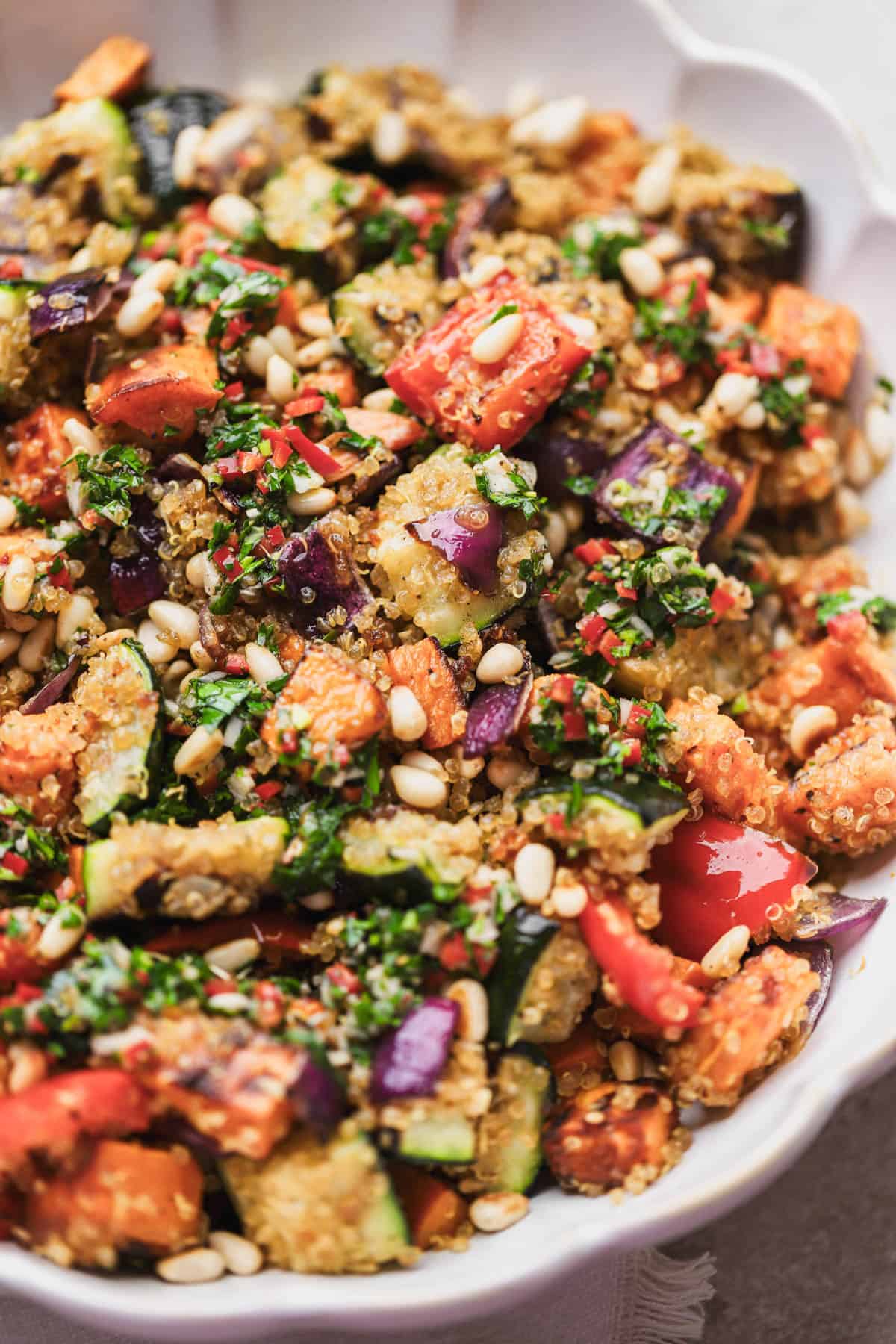 Quinoa roasted vegetable salad with crispy quinoa, zucchini, sweet potato, red onions, red bell peppers, toasted pine nuts, and chimichurri sauce. 