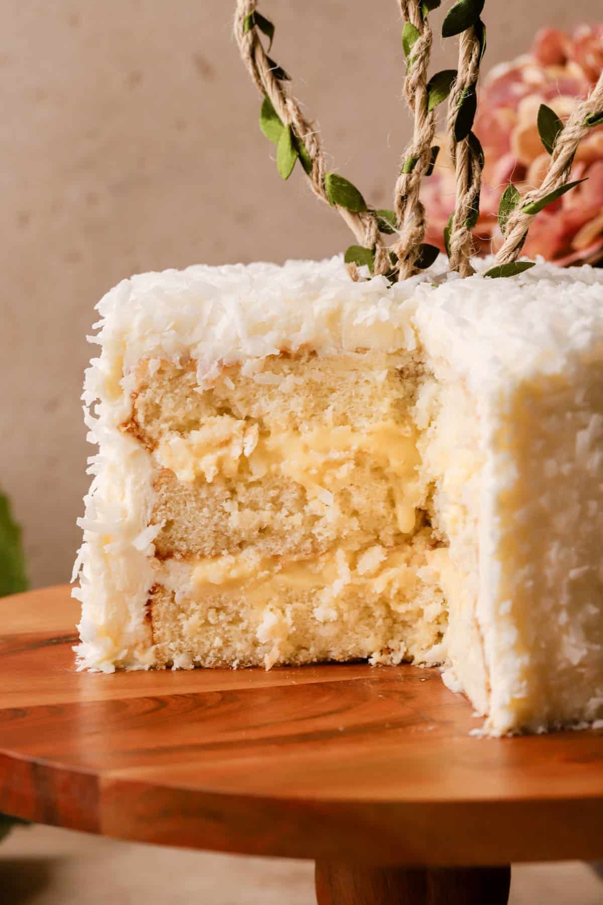 Coconut Layer Cake filled with pastry cream, covered in cream cheese frosting and shredded coconut. 