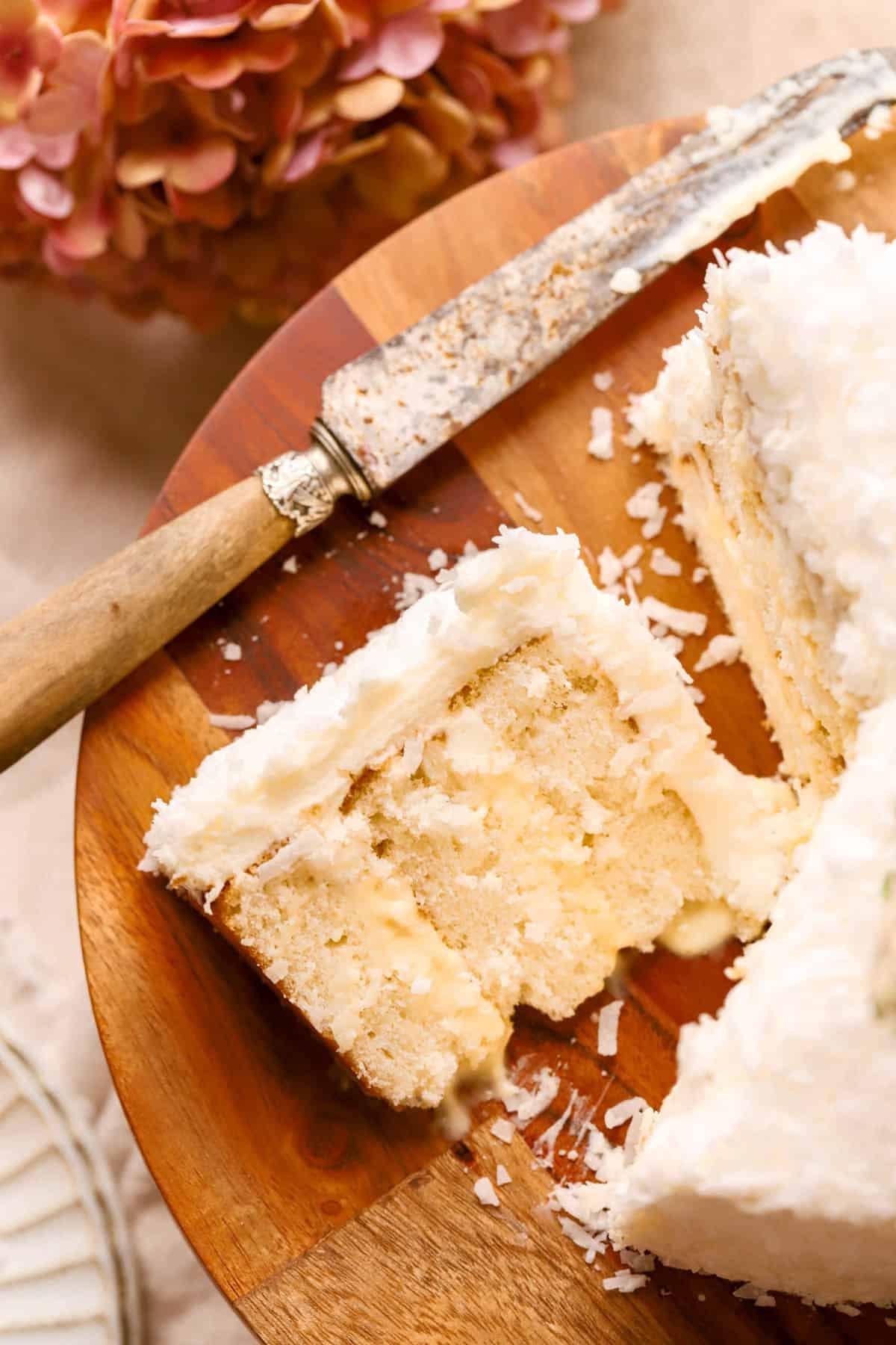 Coconut Layer Cake filled with pastry cream, covered in cream cheese frosting and shredded coconut. 