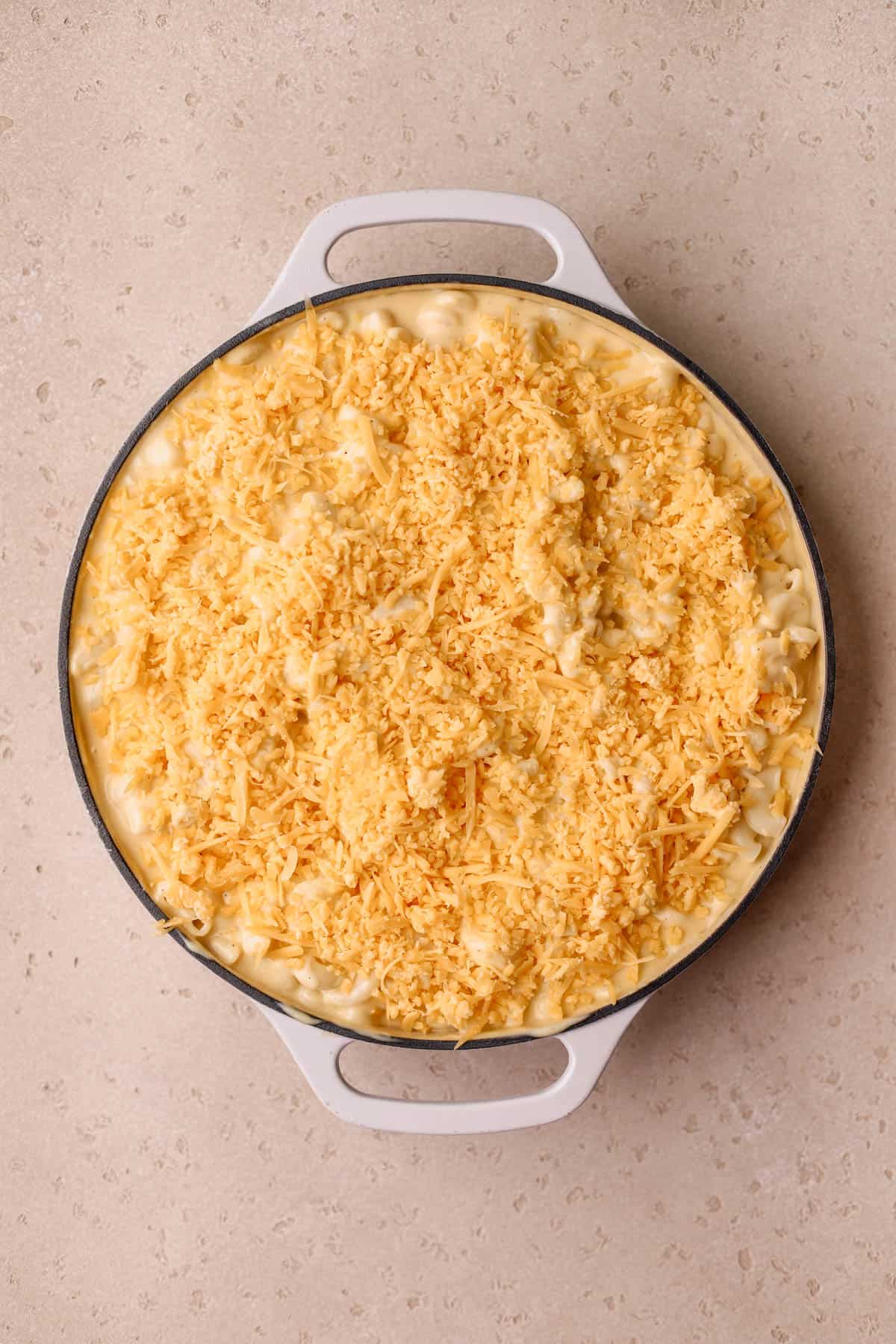 Mac and cheese topped with additional shredded cheddar cheese. 