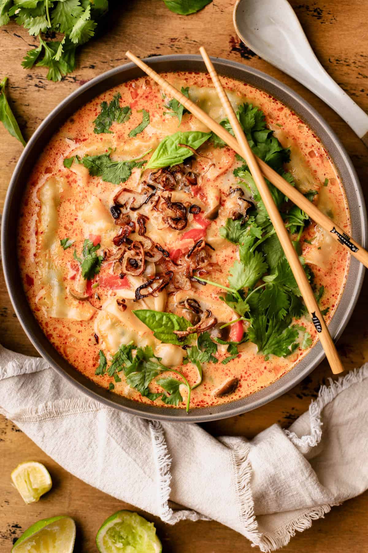 Thai red curry dumpling soup is made with fresh ginger, garlic, onions, coconut milk, mushrooms, red bell peppers, fresh herbs and crispy fried shallots. 