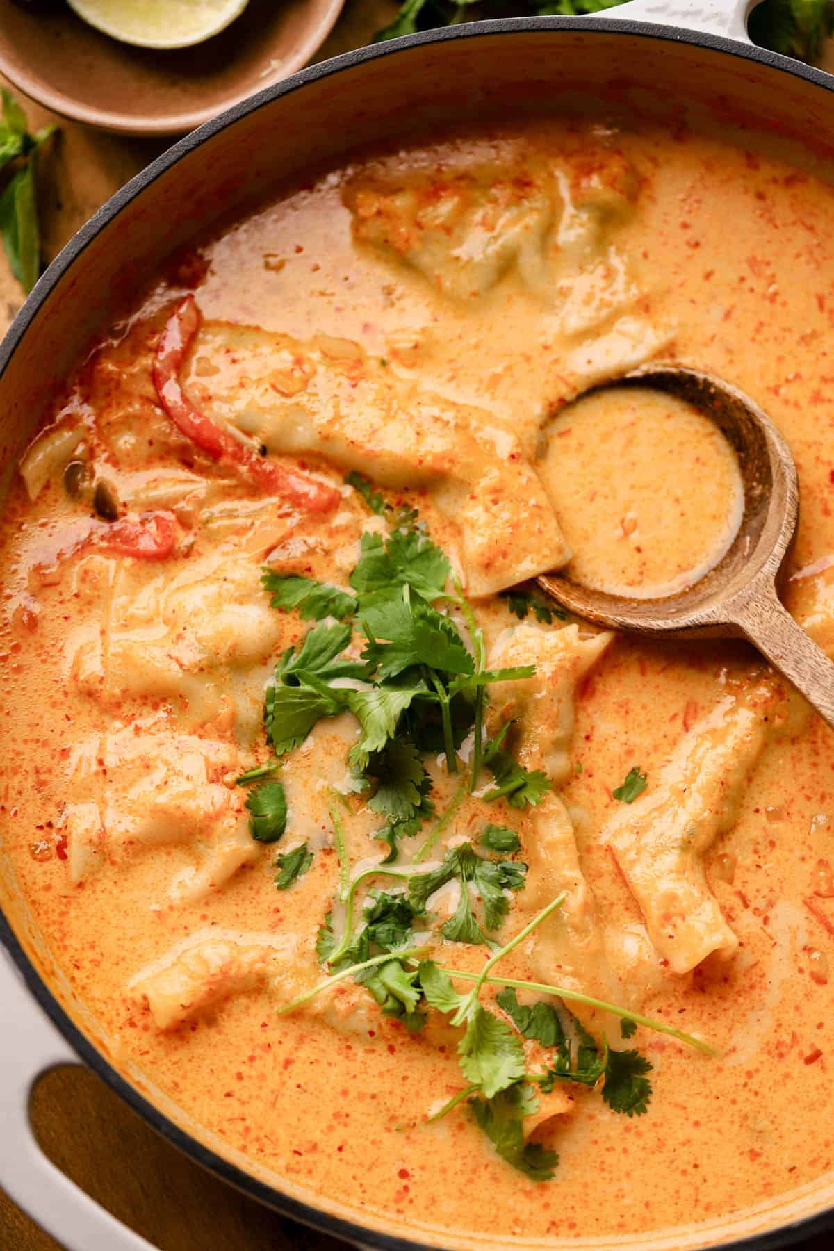 Thai red curry dumpling soup is made with fresh ginger, garlic, onions, coconut milk, mushrooms, red bell peppers, and fresh herbs.