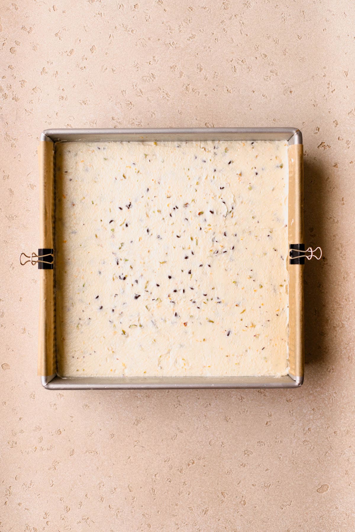 Cannoli cheesecake filling spread on top of graham cracker crust. 