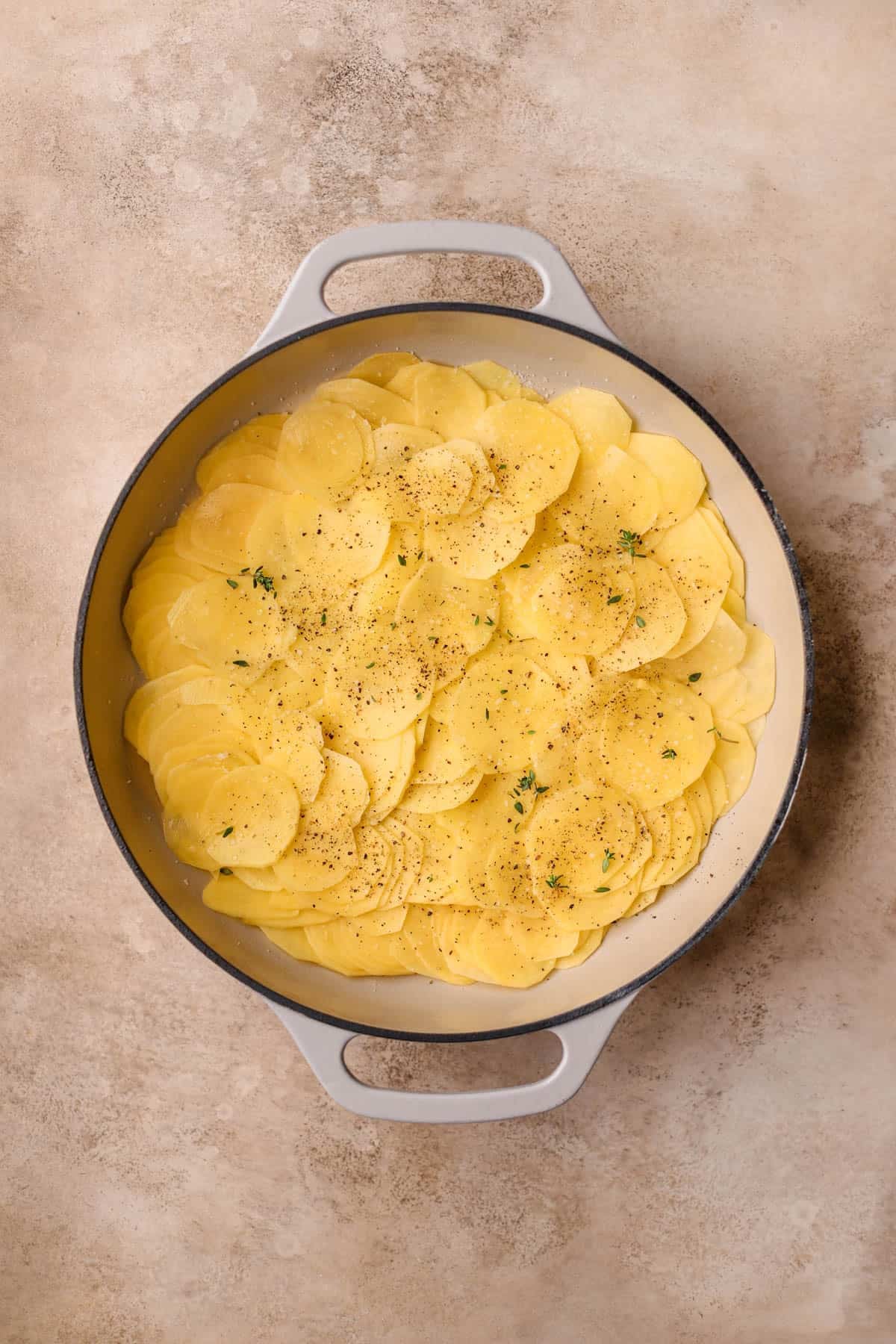 Sliced gold potatoes with salt, pepper, and fresh thyme.