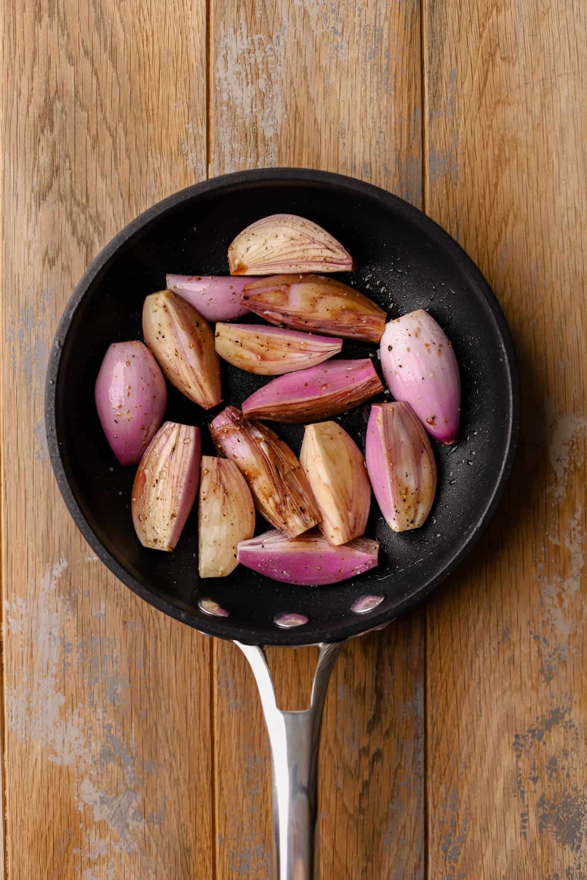 Halved shallots with balsamic and olive oil.