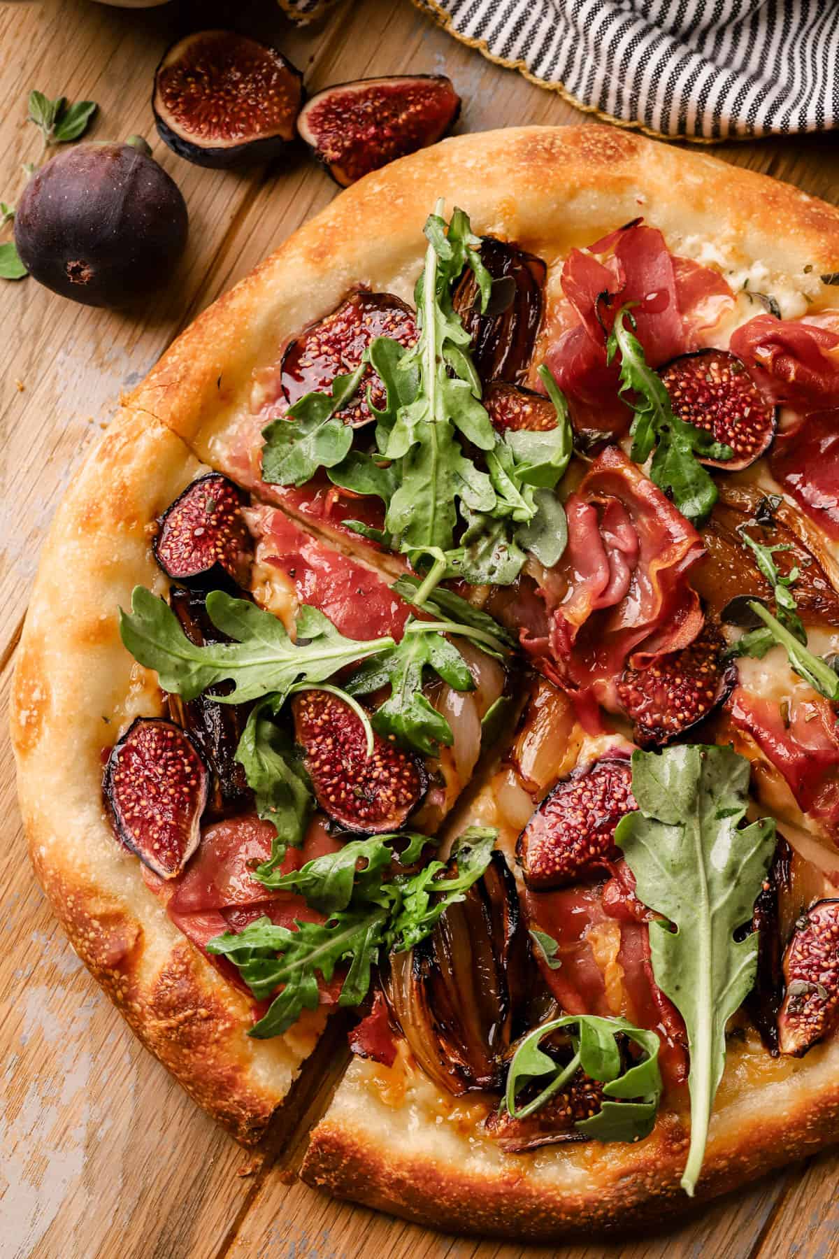 Fig Prosciutto Pizza with caramelized shallots, fontina cheese, hot honey and fresh arugula.