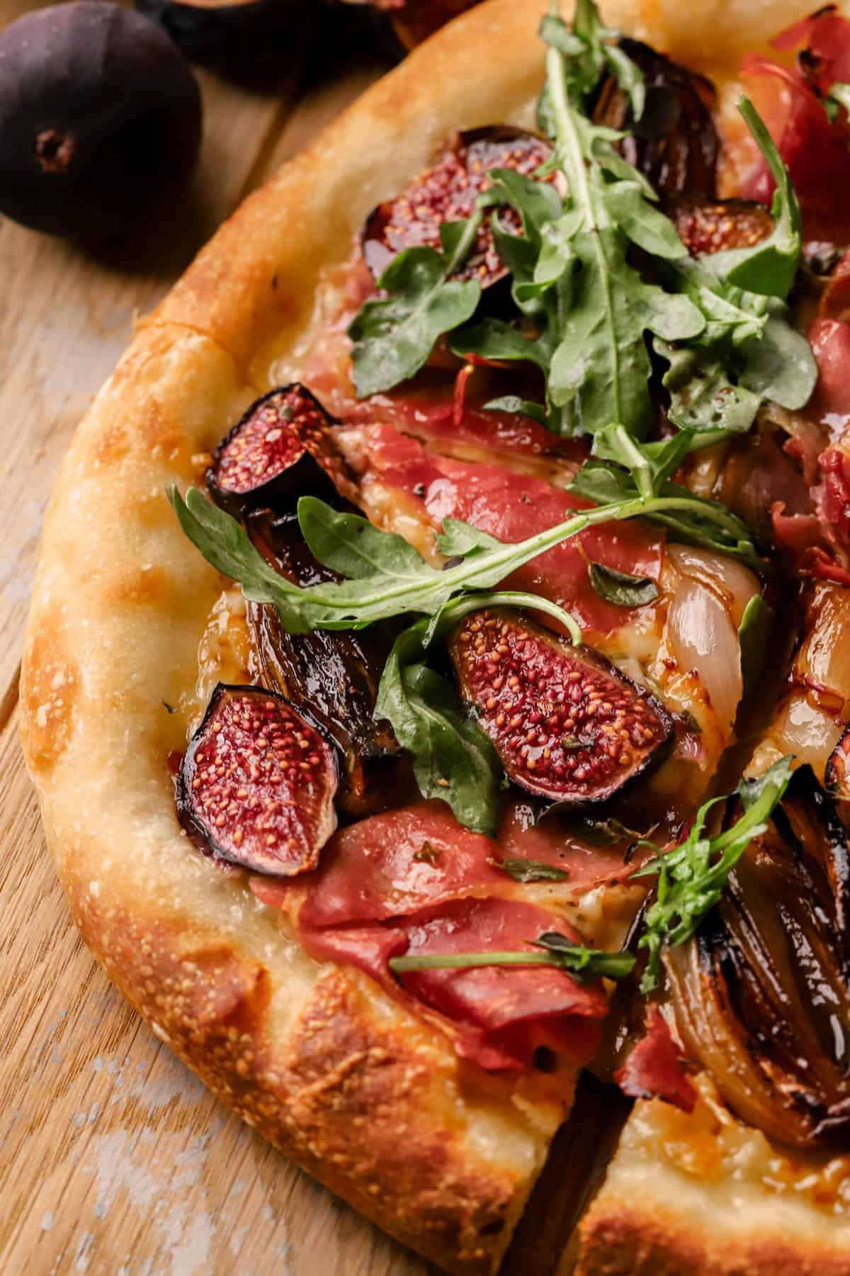 Fig Prosciutto Pizza with caramelized shallots, fontina cheese, hot honey and fresh arugula.