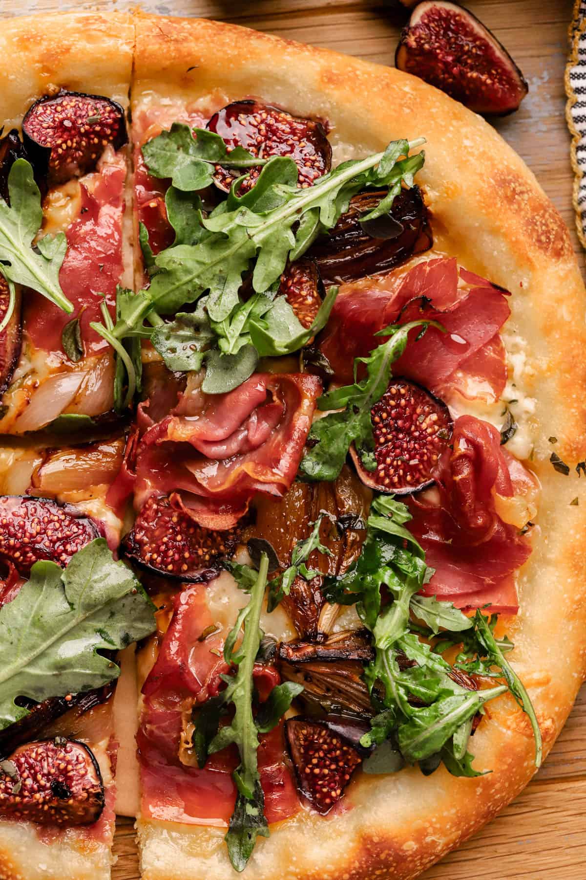 Fig Prosciutto Pizza with caramelized shallots, fontina cheese, hot honey and fresh arugula.