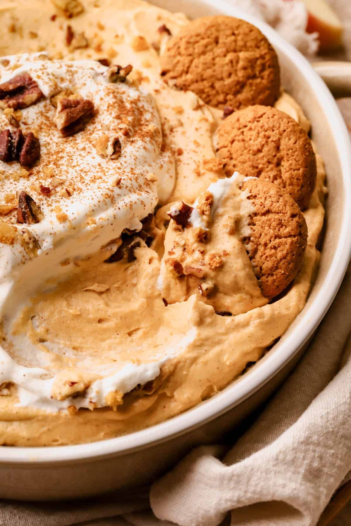 Pumpkin fluff recipe made with cream cheese, brown sugar, pumpkin puree, pumpkin spice, homemade whipped cream, vanilla extract and served with gingersnap cookies and apples.