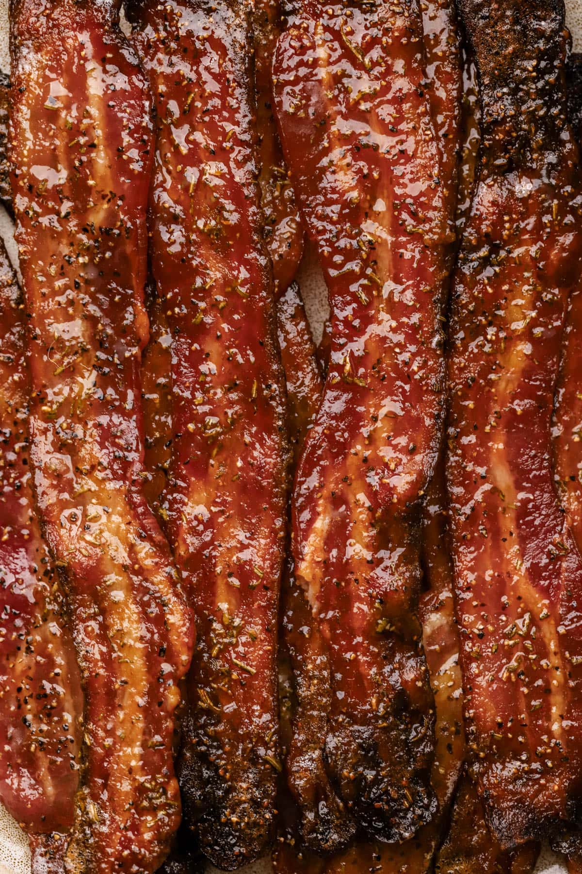 Candied bacon with thick-cut bacon, brown sugar, maple syrup, coarse black pepper, paprika, and fresh rosemary.