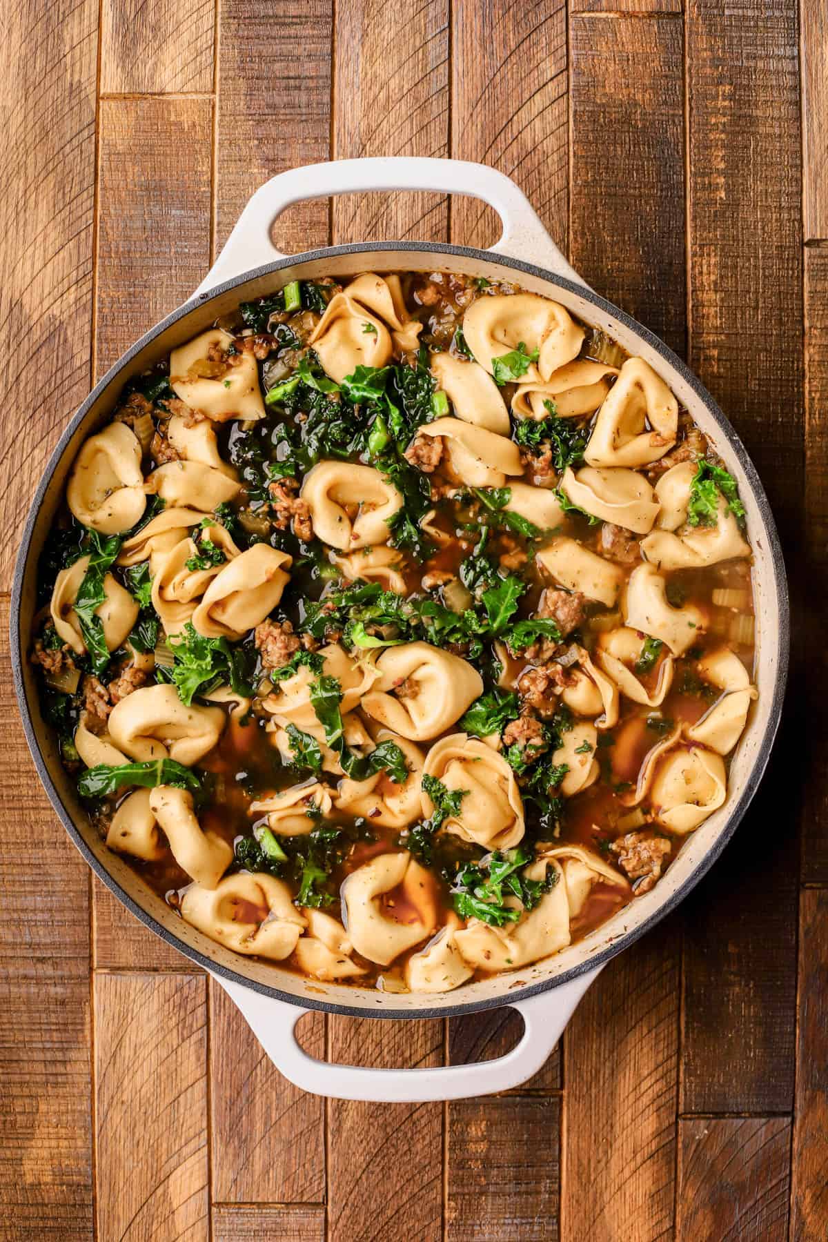 Browned Italian sausage, olive oil, yellow onions, celery, garlic, red pepper flakes, Italian seasoning, chicken broth, cheese tortellini and kale.