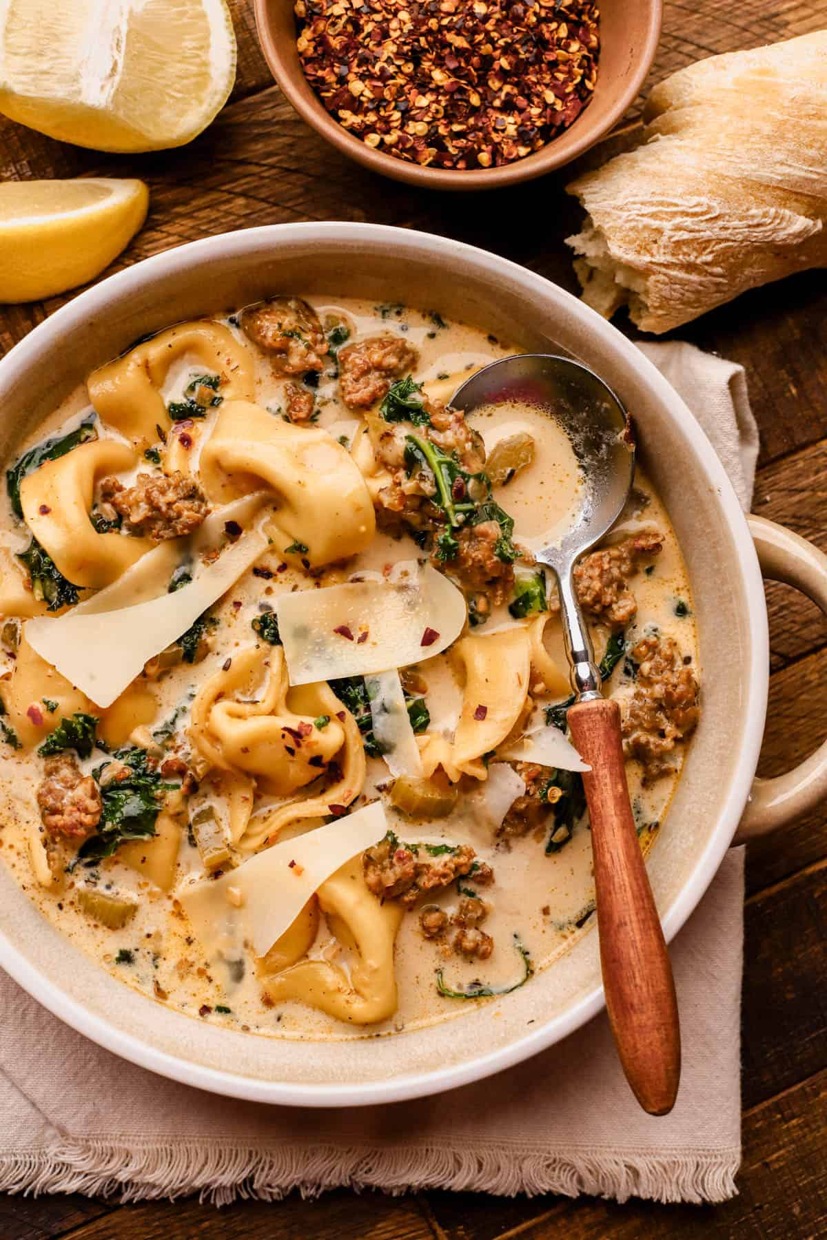Tuscan tortellini soup is made with Italian sausage, kale, cheese tortellini, red pepper flakes, onions, garlic, celery, heavy cream and parmesan cheese.