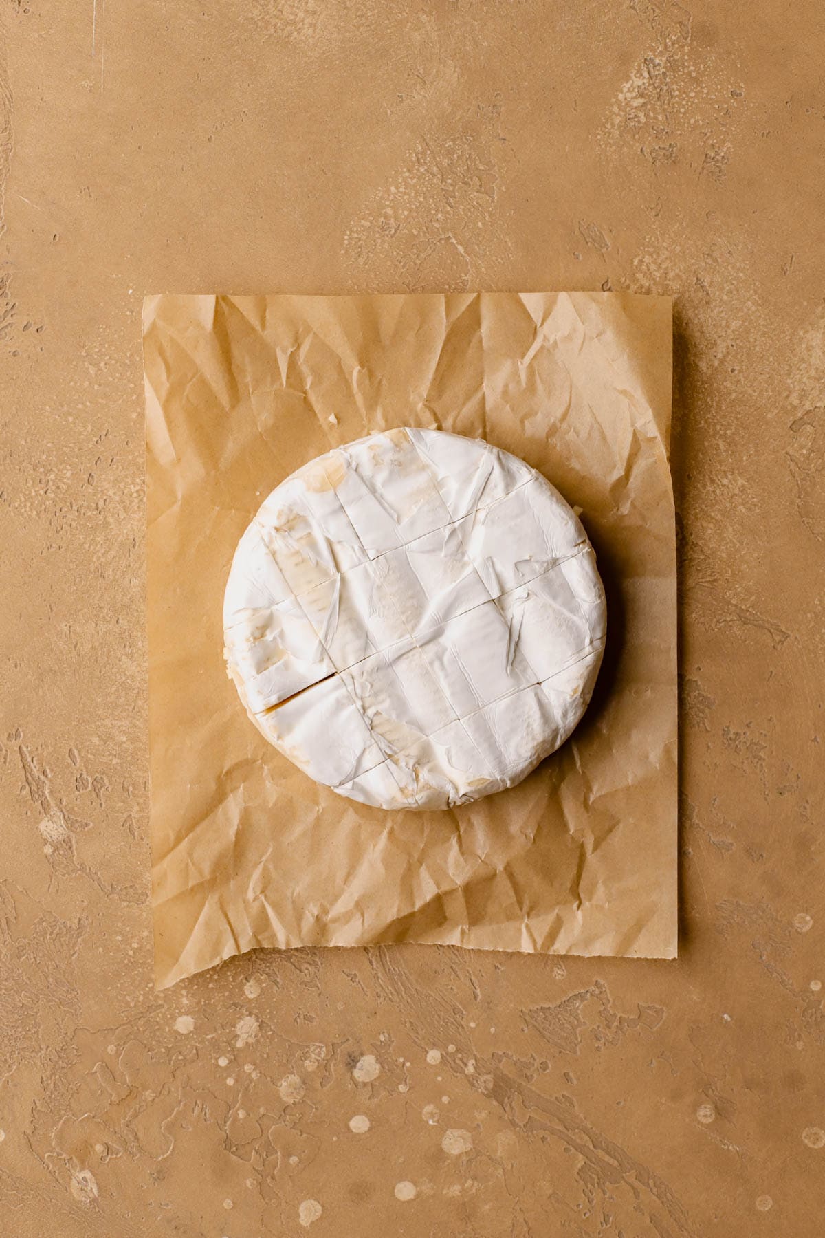 Wheel of brie with cut slits.  