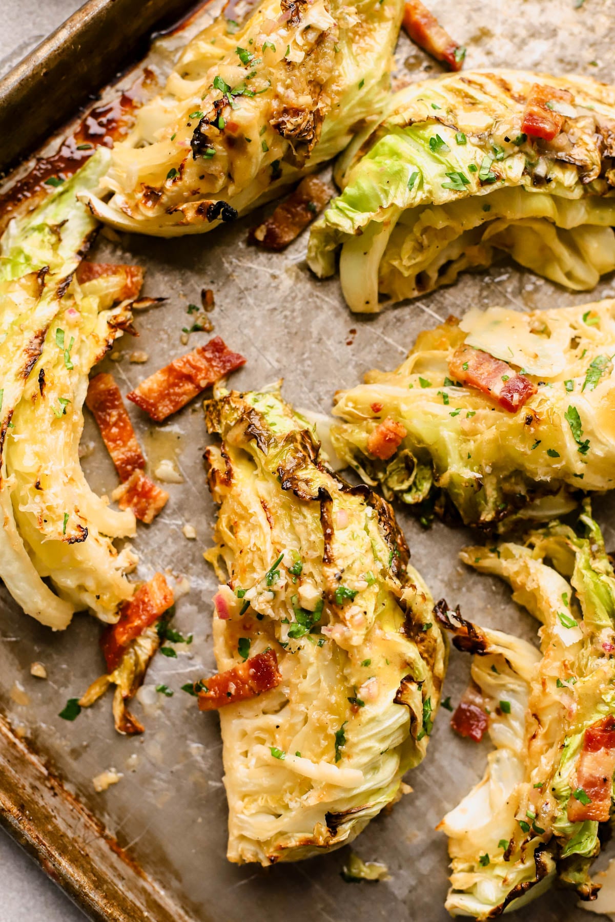 Roasted cabbage salad is cut into large wedges and roasted with garlic and honey, then finished with mustard vinaigrette, herbs, and bacon. 