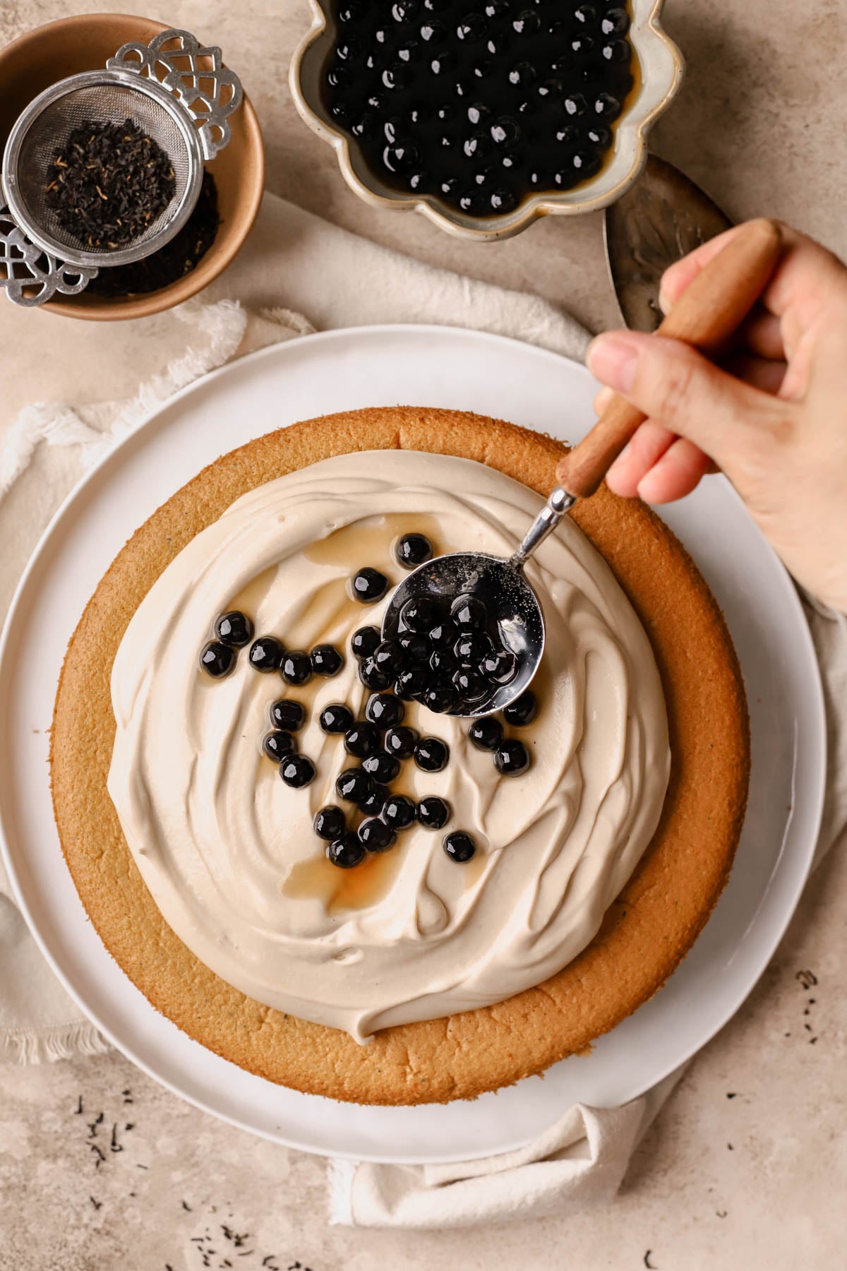 Milk tea boba cake with soft sponge layers and glossy brown sugar tapioca pearl topping. 