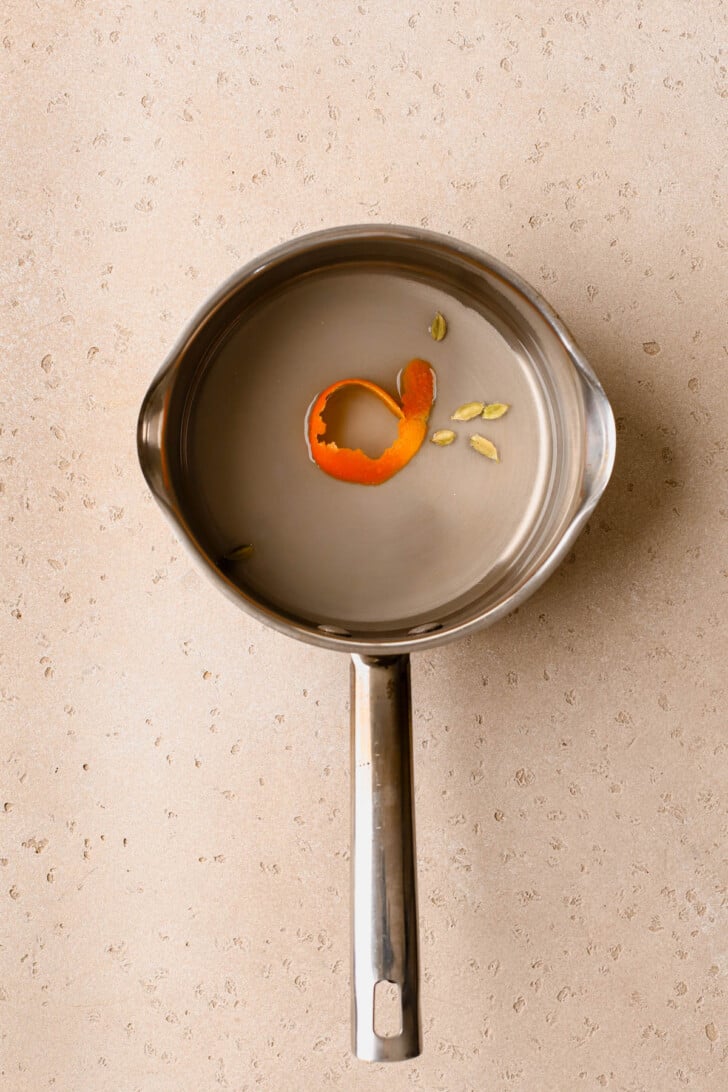 Sugar, orange zest, water, and cardamom pods. 