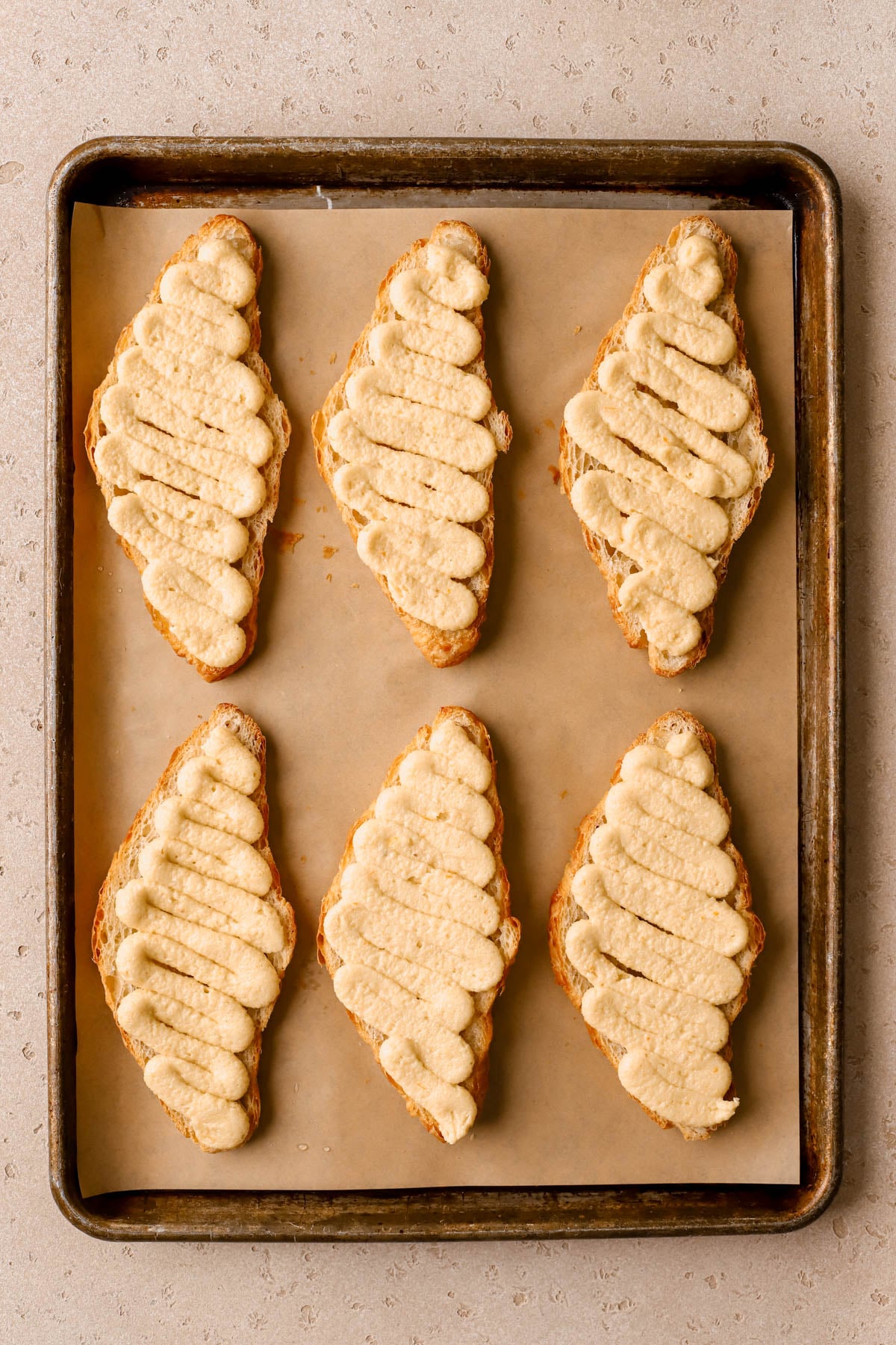 Frangipane filling piped onto bottom half of croissants. 