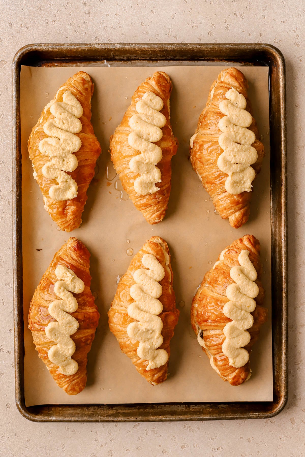 Almond frangipane cream piped on top of croissants. 