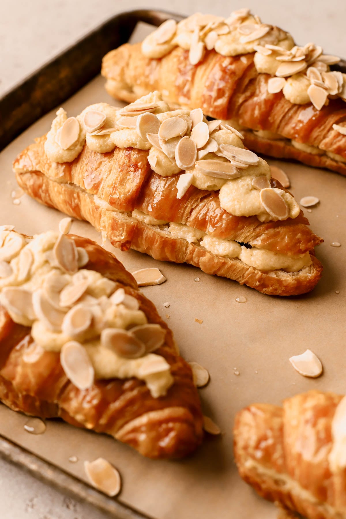 Homemade chocolate almond croissant made with store-bought croissants and filled with orange frangipane, and topped with sliced almonds. 