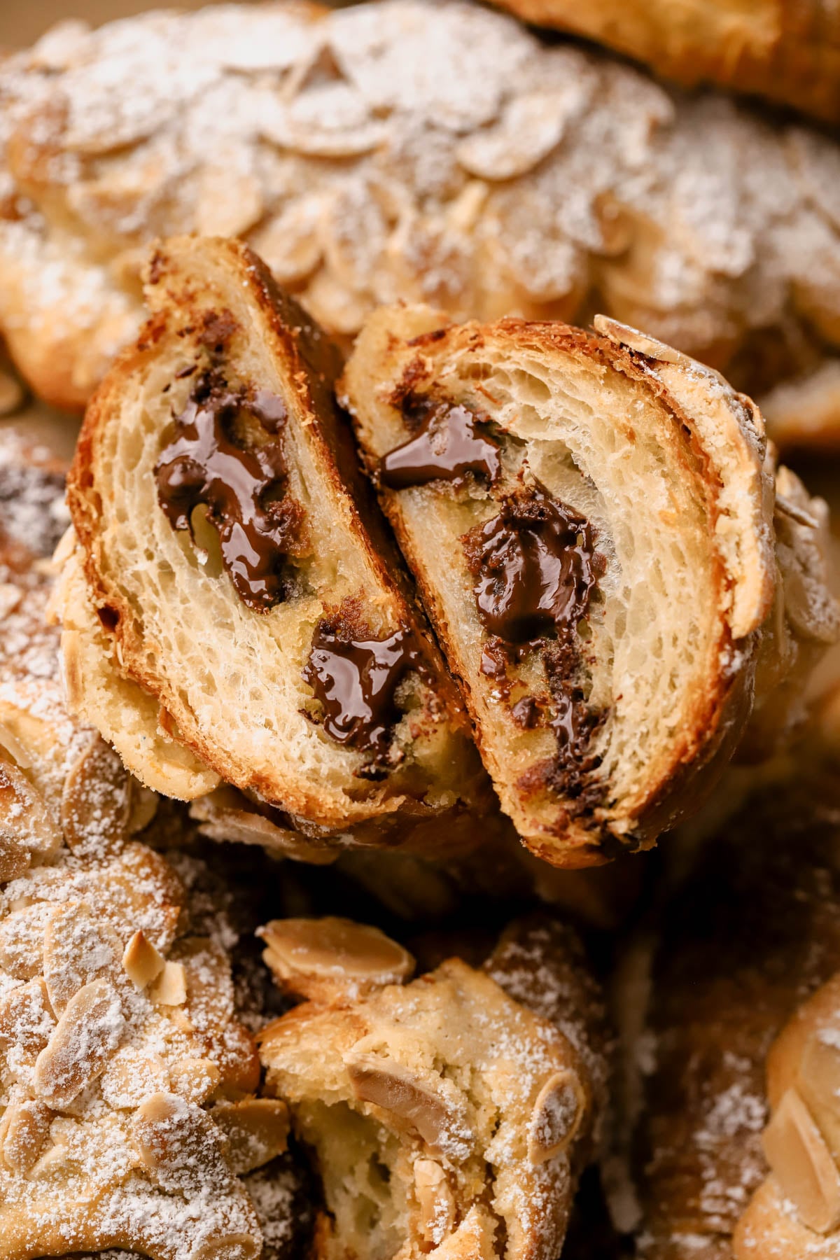 Close up of chocolate almond croissant with flaky layers and melted chocolate center.  