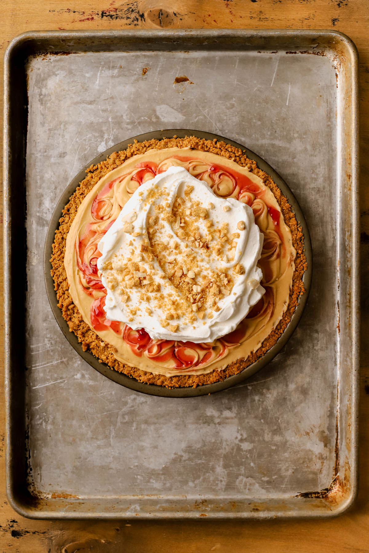 Chilled peanut butter and jelly pie topped with whipped cream, peanuts, and crushed Nutter Butter cookies. 
