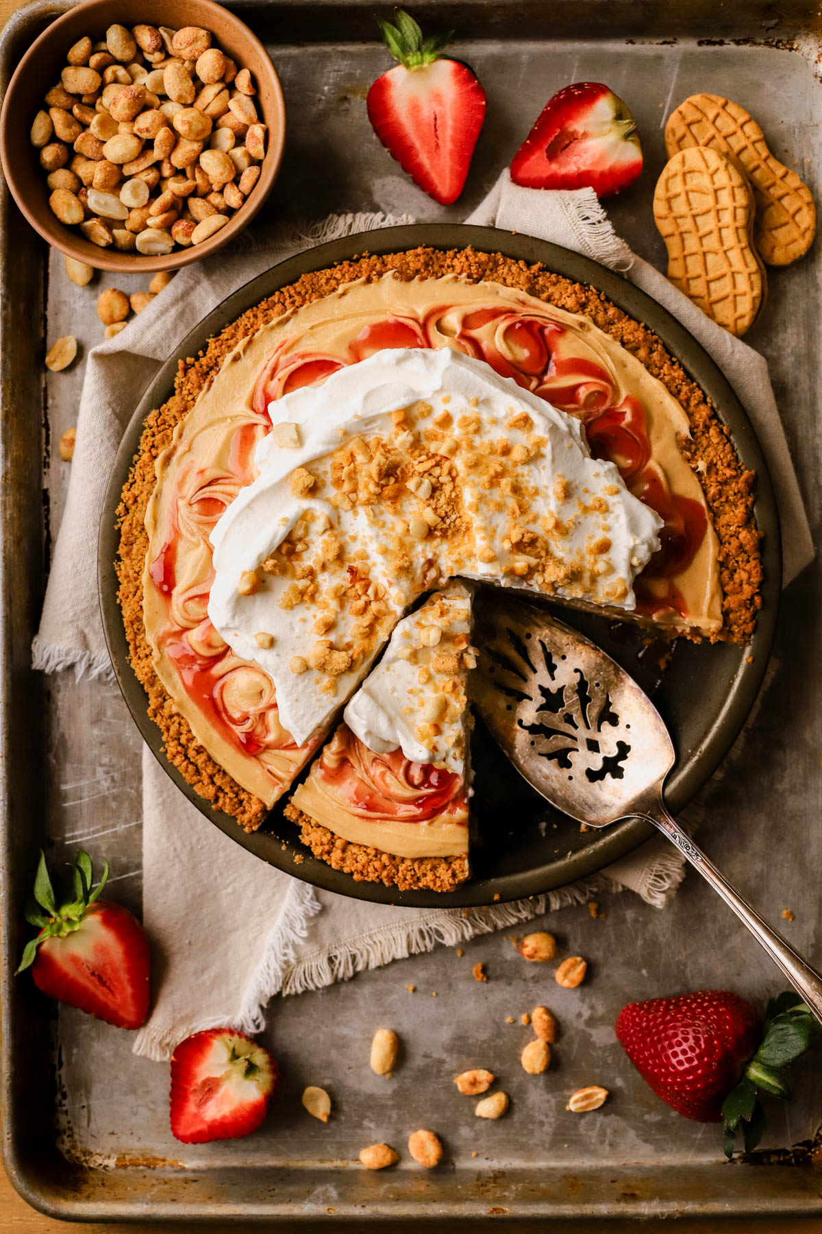 Peanut butter and jelly pie with whipped cream, Nutter Butter cookies, honey roasted peanuts, and swirls of strawberry jam. 