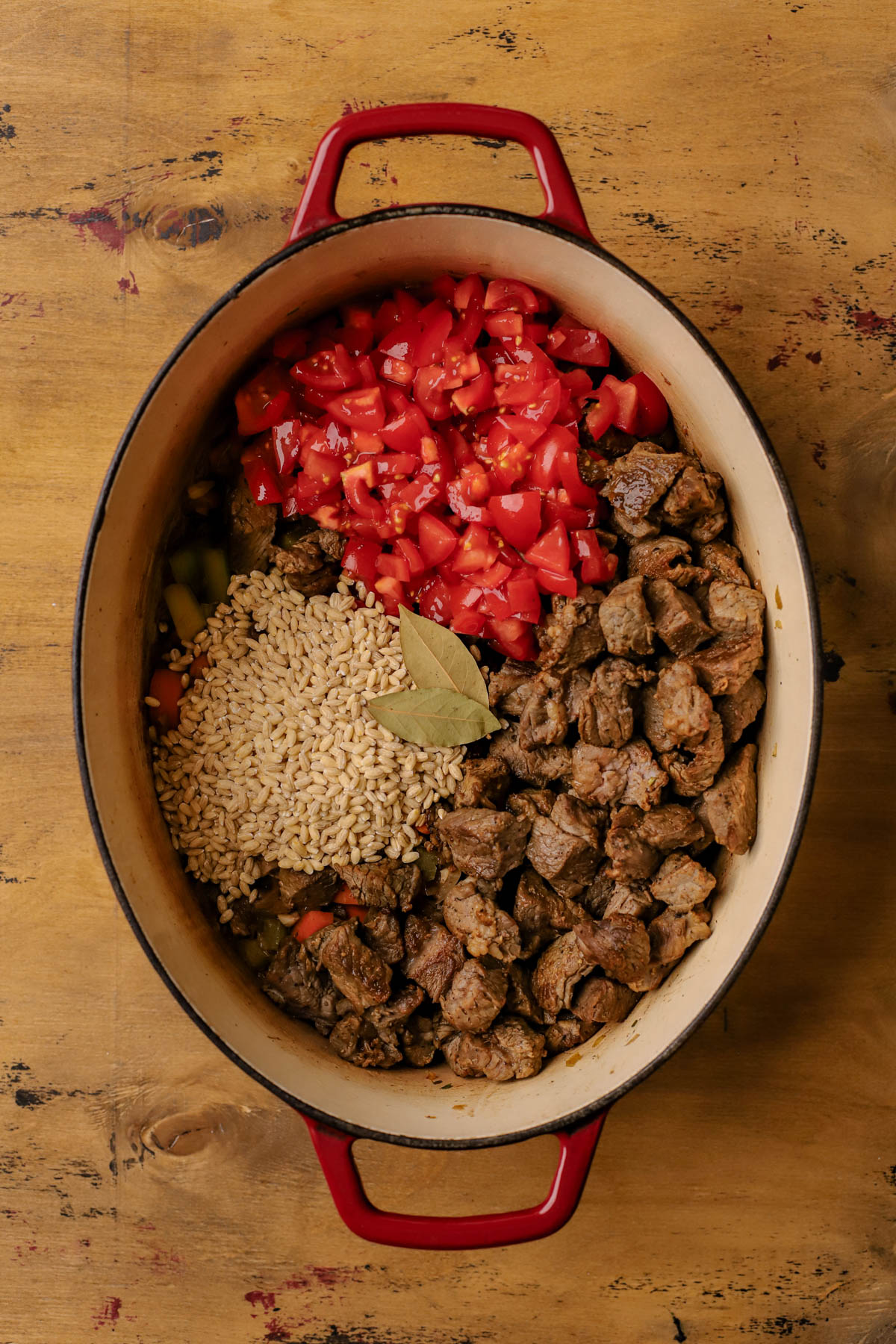 Diced tomatoes, bay leaves, seared beef, barley, onions, garlic, celery, herbs, and carrots.