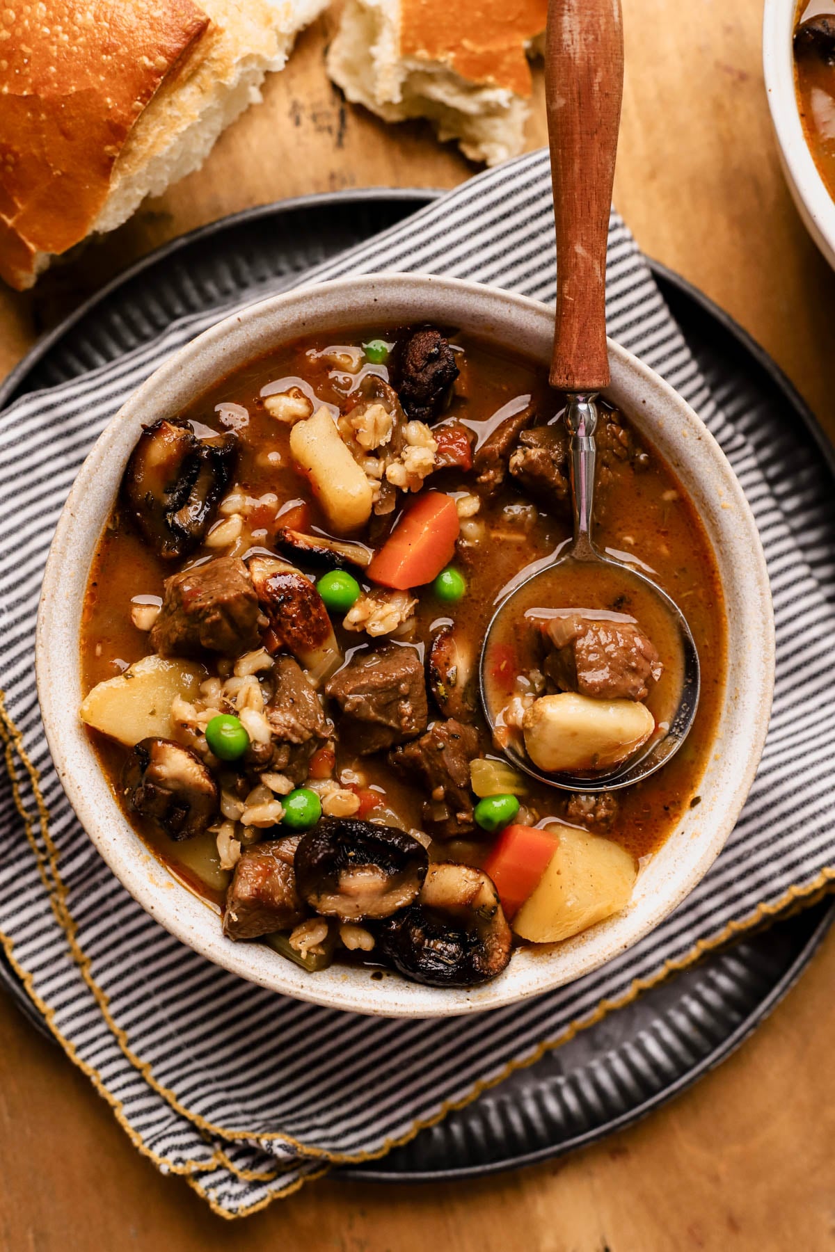 Beef barley mushroom soup with vegetables, potatoes, red wine, and roasted mushrooms with garlic.