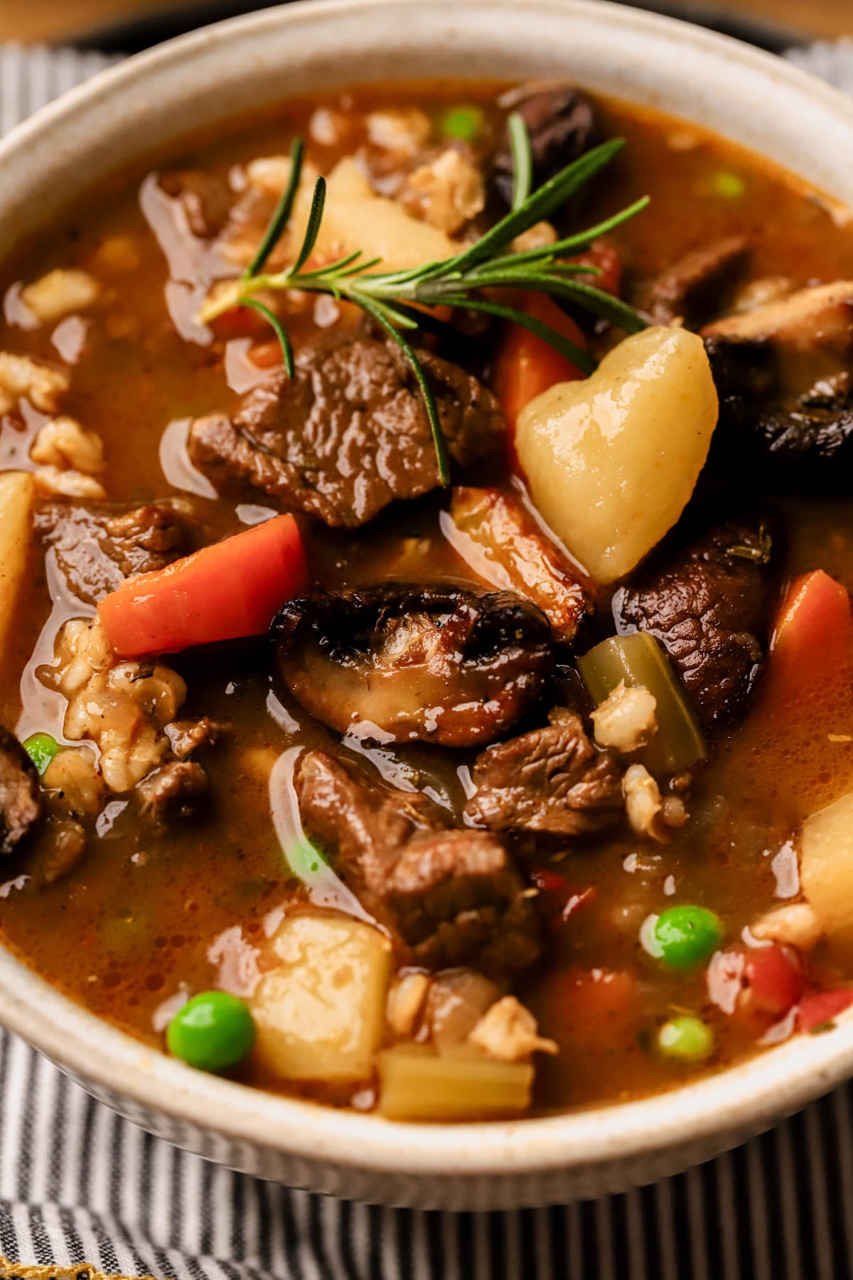 Beef barley mushroom soup with caramelized mushrooms, potatoes, veggies, and peas. 